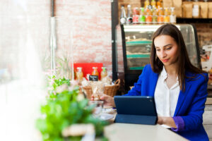 women works with tablet table cafe